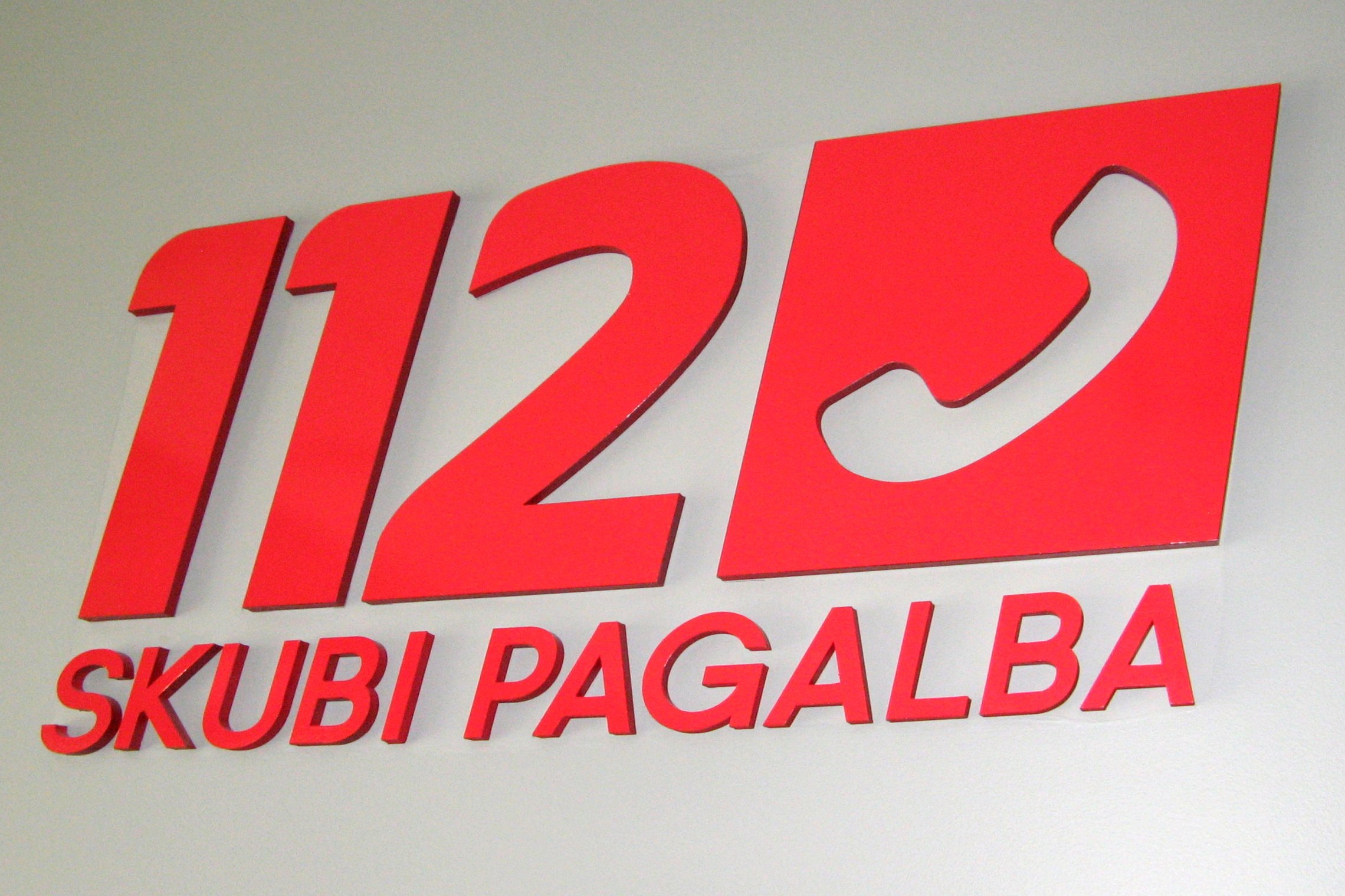 Matomas vestibiulyje ant sienos esantis numerio 112 logotipas