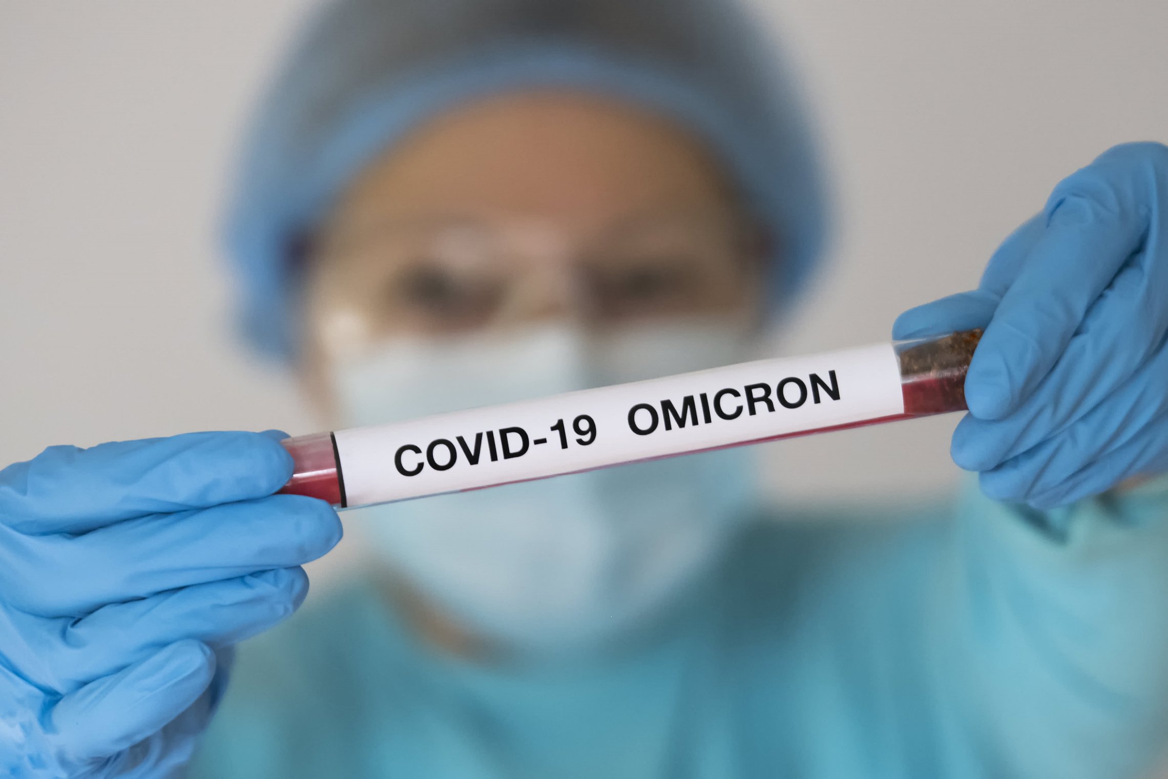 Nuotraukoje matomas medikės rankose laikomas mėgintuvėlis su COVID-19 mėginiu