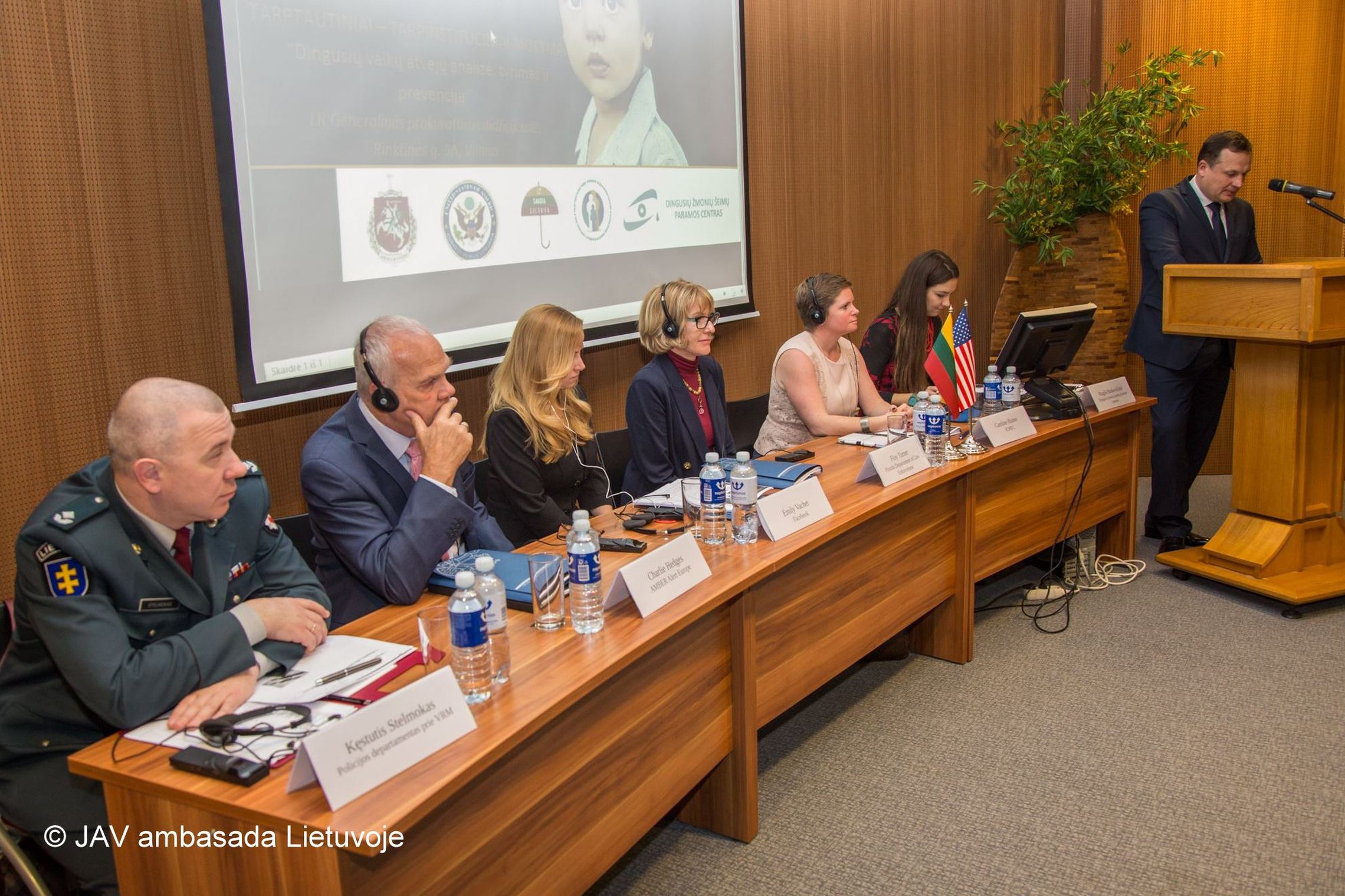 Nuotraukoje matomi prie stalo sėdintys pranešėjai