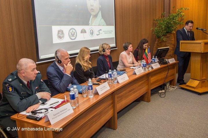 Nuotraukoje matomi prie stalo sėdintys pranešėjai