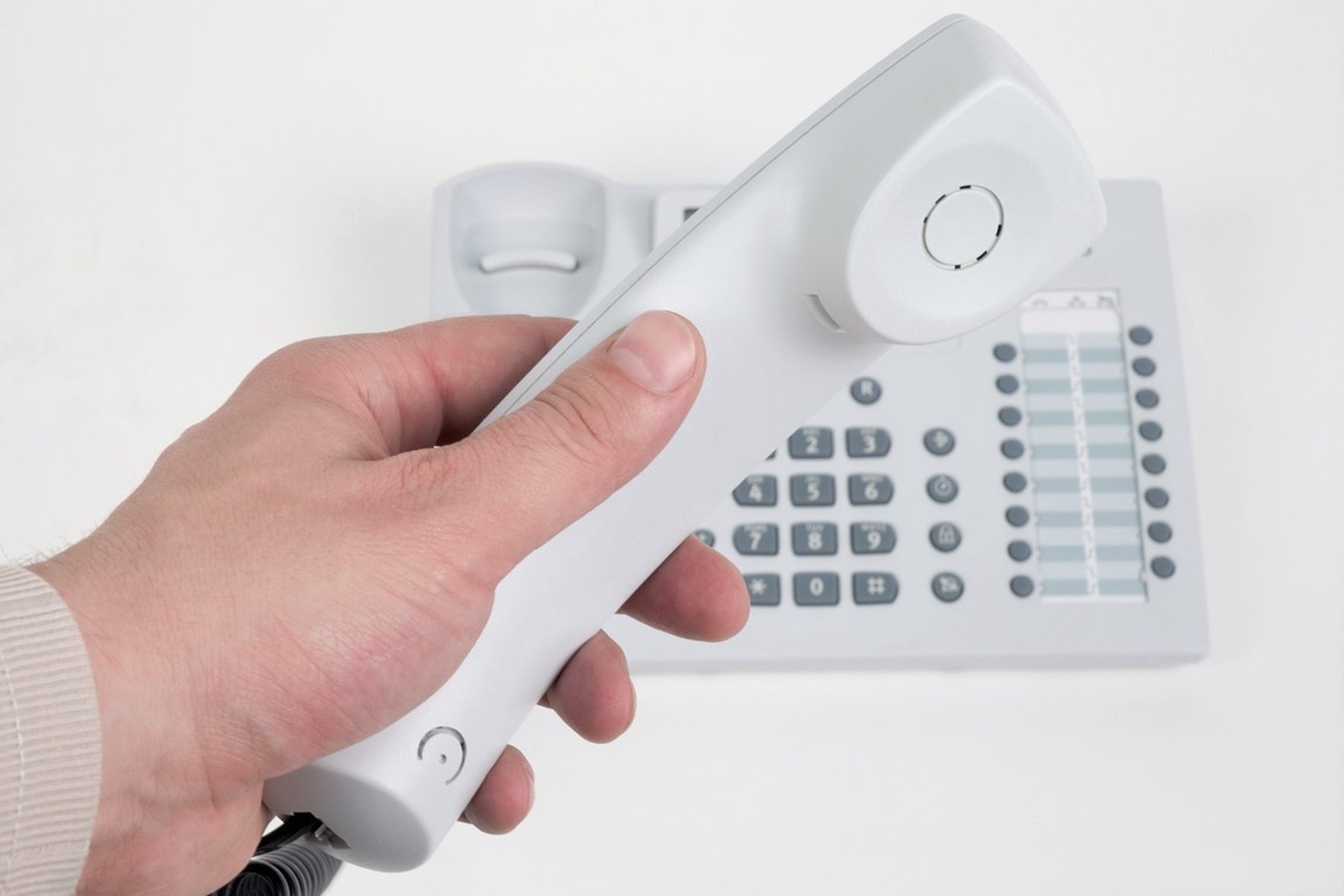 Nuotraukoje matomas rankoje laikomas ragelis ir telefono aparatas