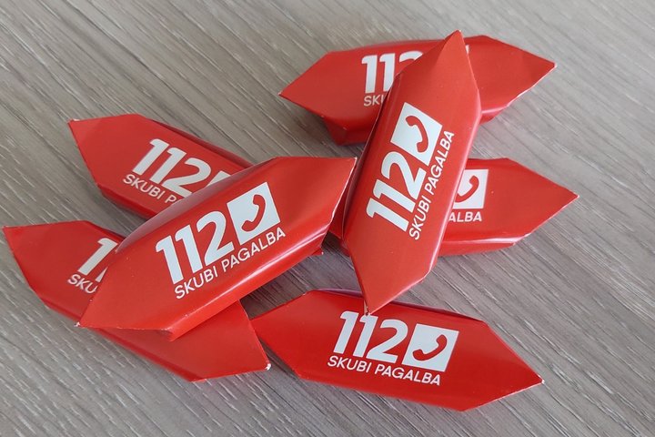 Nuotraukoje matomi saldainiai su numerio 112 logotipu