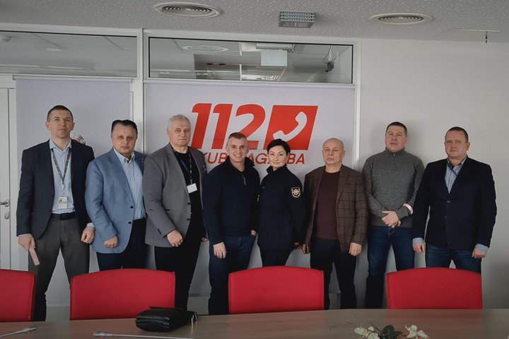 Nuotraukoje matosi prie sienos Posėdžių salėje sustoję ir nusifotografavę žmonės