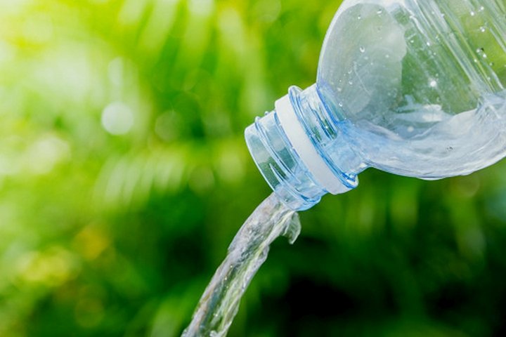 Nuotraukoje matomas iš plastikinio butelio pilamas vanduo