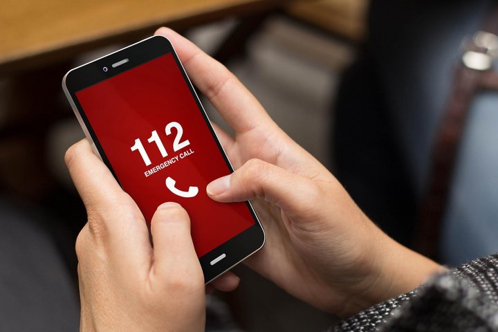 Nuotraukoje matomas rankose laikomas mobilusis telefonas su skaičiais 112 ekrane