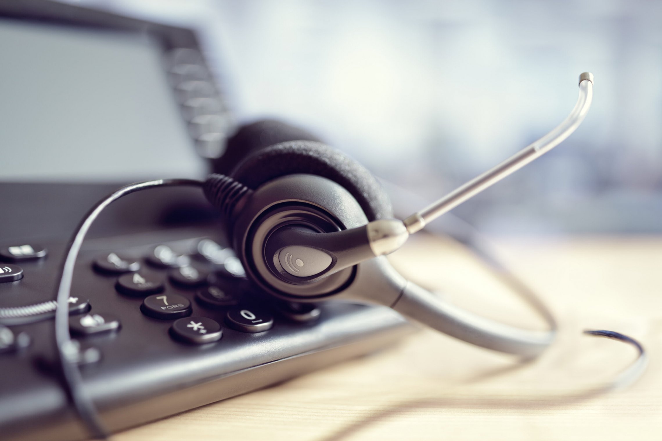 Nuotraukoje matomas telefonas ir operatoriaus ausinės