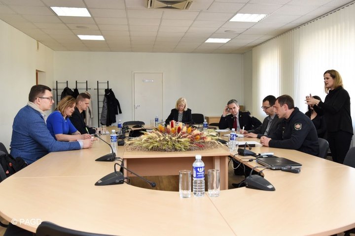 Nuotraukoje matomi prie apvalaus stalo posėdžiaujantys asmenys