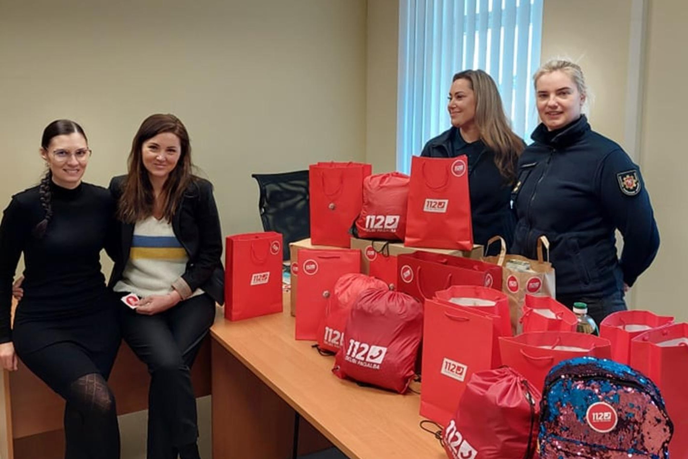 Nuotraukoje matomos Bendrojo pagalbos centro darbuotojos su maišeliuose sukrauta parama