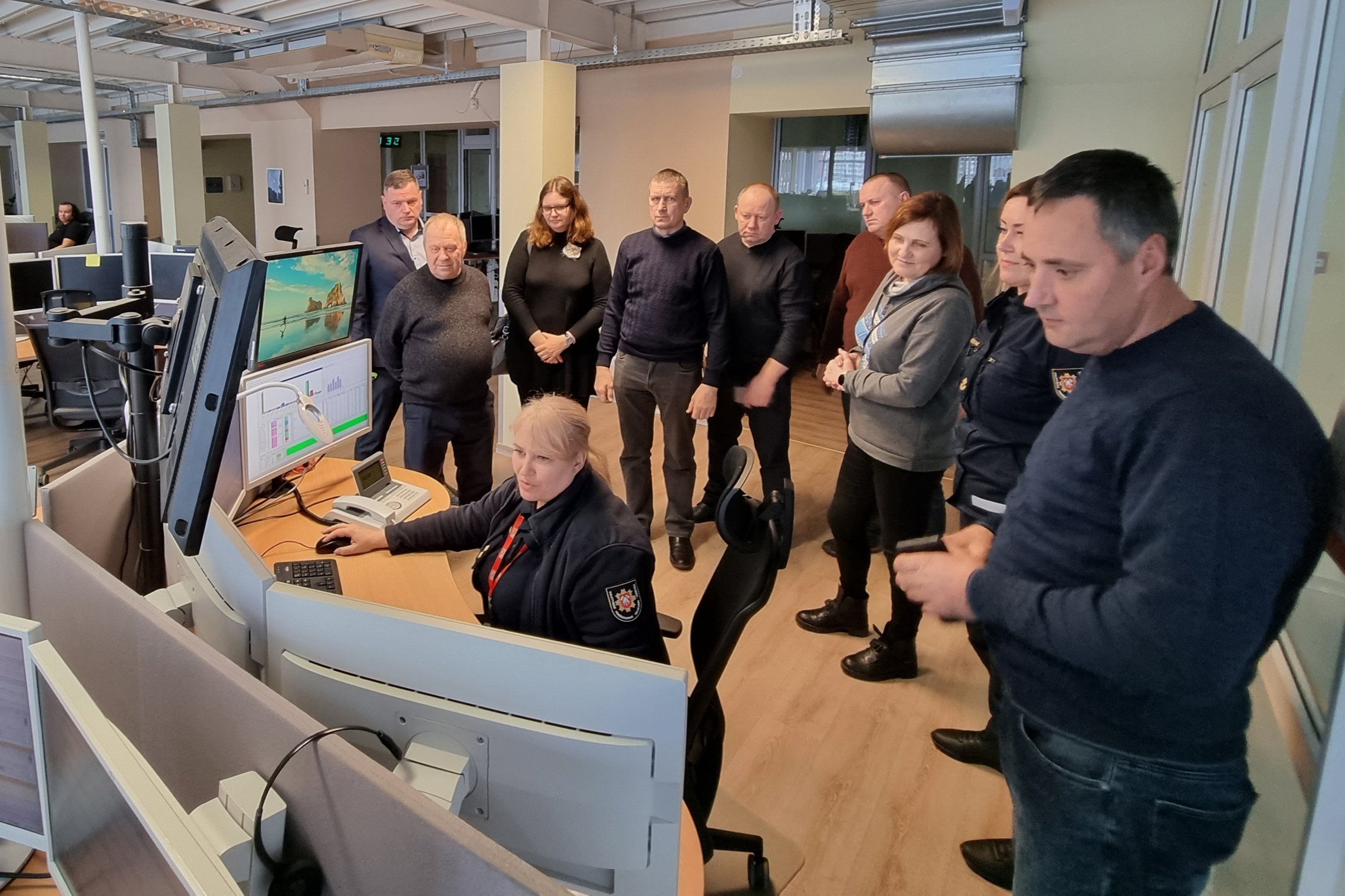 Nuotraukoje matomi operatoriaus darbą stebintys žmonės