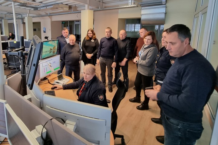 Nuotraukoje matomi operatoriaus darbą stebintys žmonės
