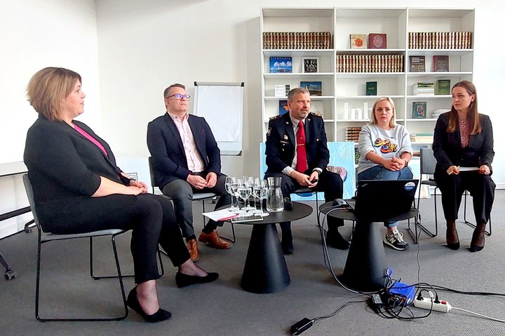 Nuotraukoje matomi sėdintys diskusijos dalyviai