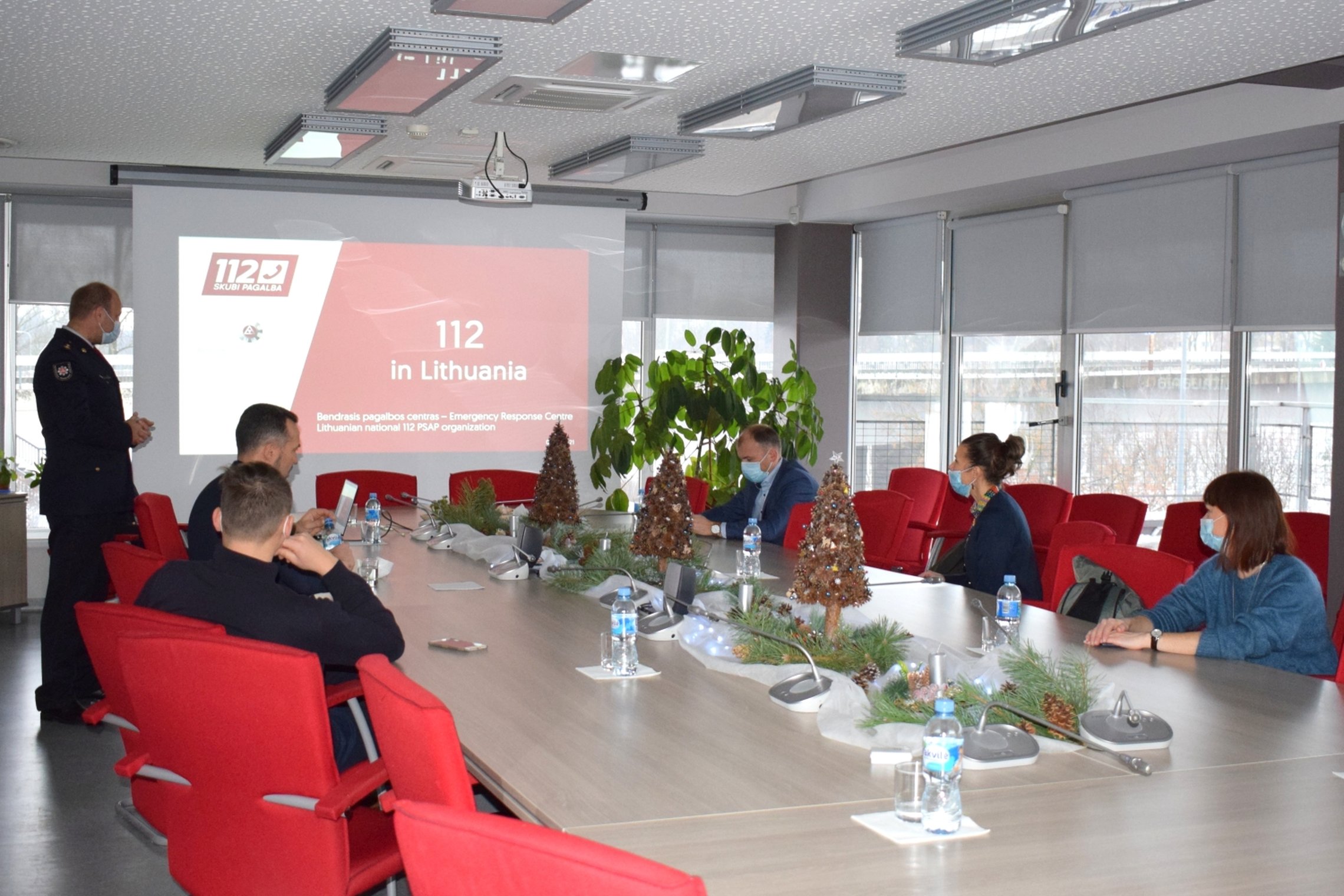 Nuotraukoje matomi Posėdžių salėje prie stalo sėdintys žmonės