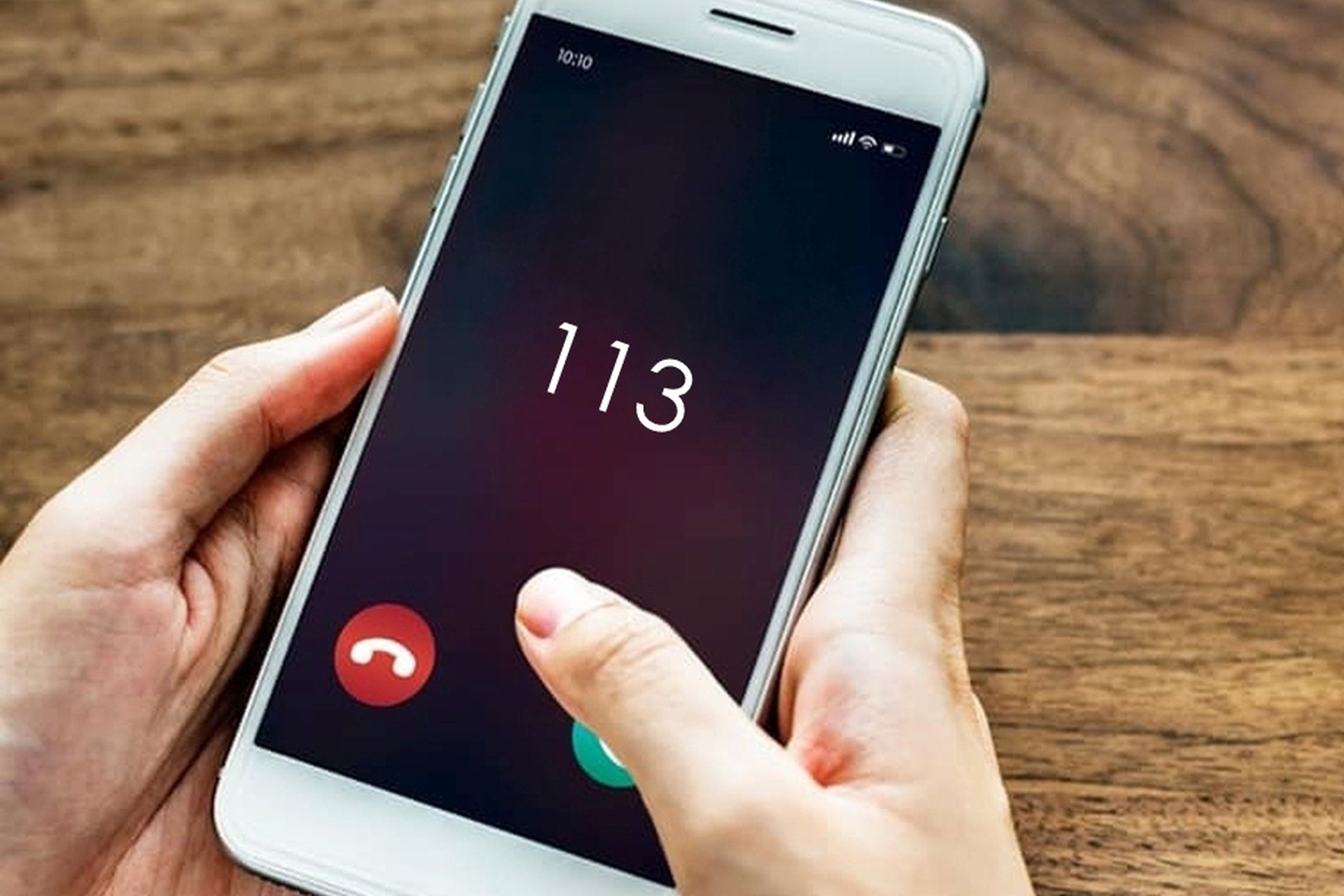 Nuotraukoje matomas rankose laikomas mobilusis telefonas, kurio ekrane matomas numeris 113