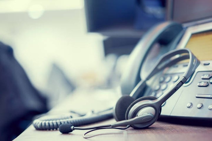 Nuotraukoje matomos operatoriaus ausinės ir telefono aparatas