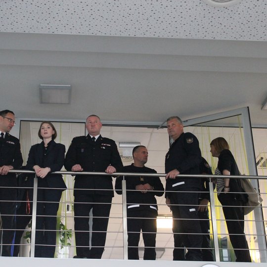 Nuotraukoje matomi svečiai ir juos lydintys asmenys balkonėlyje