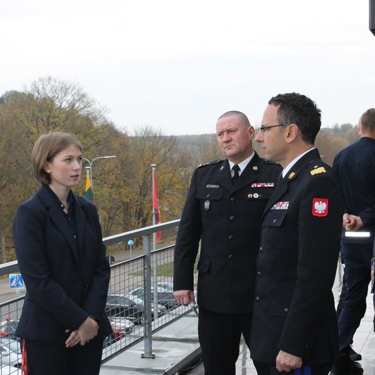 Nuotraukoje matoma pristatymą vedusi operatorė ir svečiai terasoje